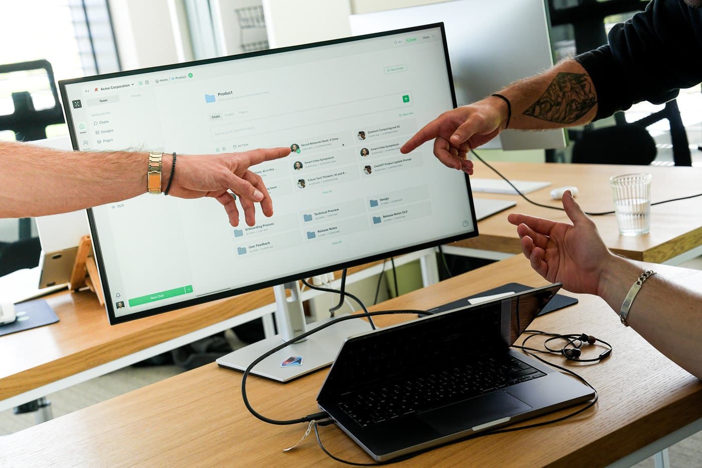 Two Juma engineers at a client's desk, working through the operation on a monitor together.